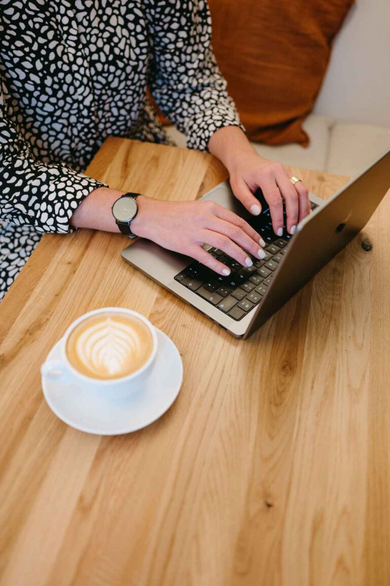 Hände auf der Laptop Tastatur um ein Konzept zu erstellen. Ein Kaffee steht daneben