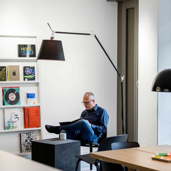 Norbert Möller sitzt in seiner Leseecke und liest ein Buch