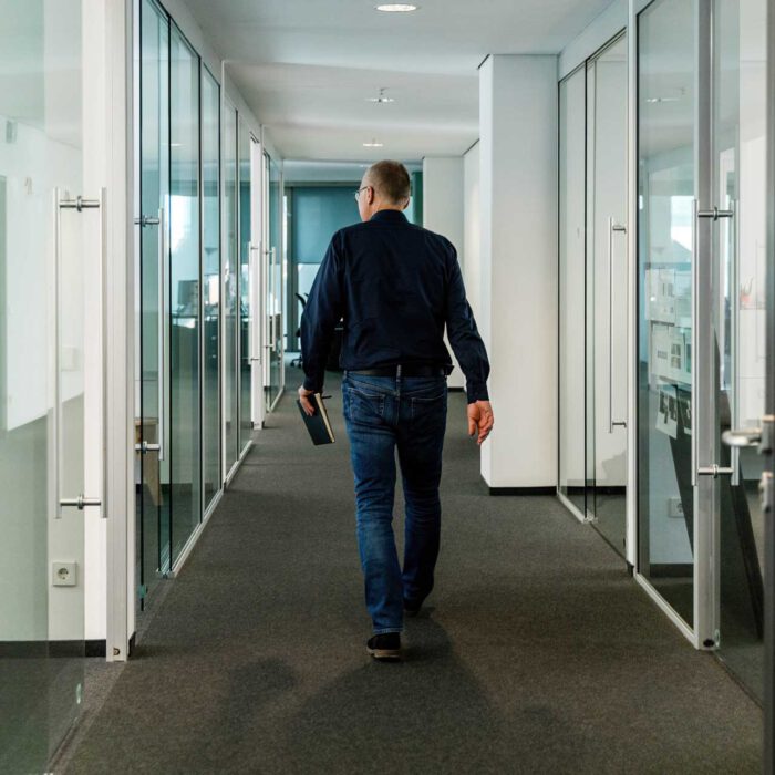 Einblick in Büroalltag in Hamburg. Norbert Möller läuft durch den Flur und ist von hinten zu sehen.